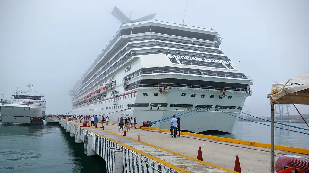 El crucero Carnival Freedom atracado en el muelle de Progreso, con pasajeros caminando junto al barco (foto de 2016).